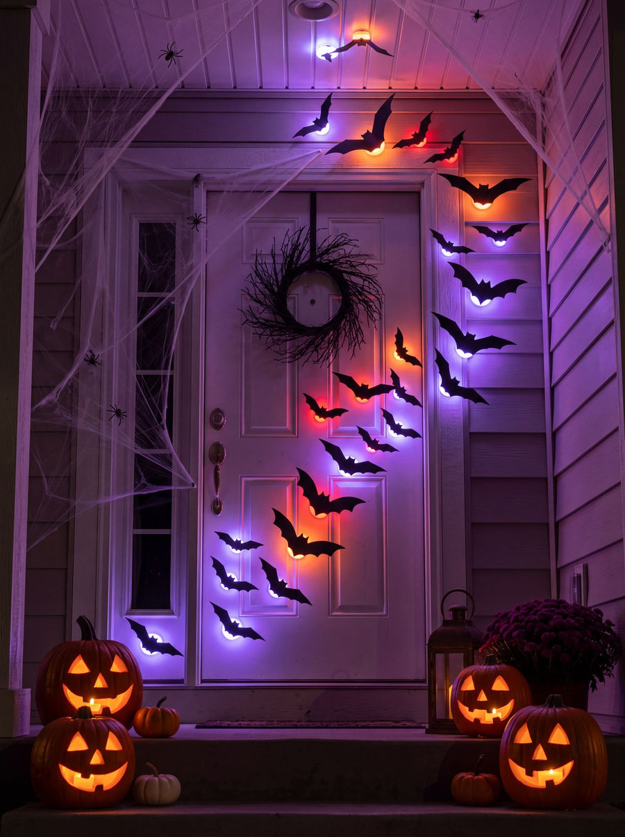 GlowBats around a front door with jack-o-lanterns at night