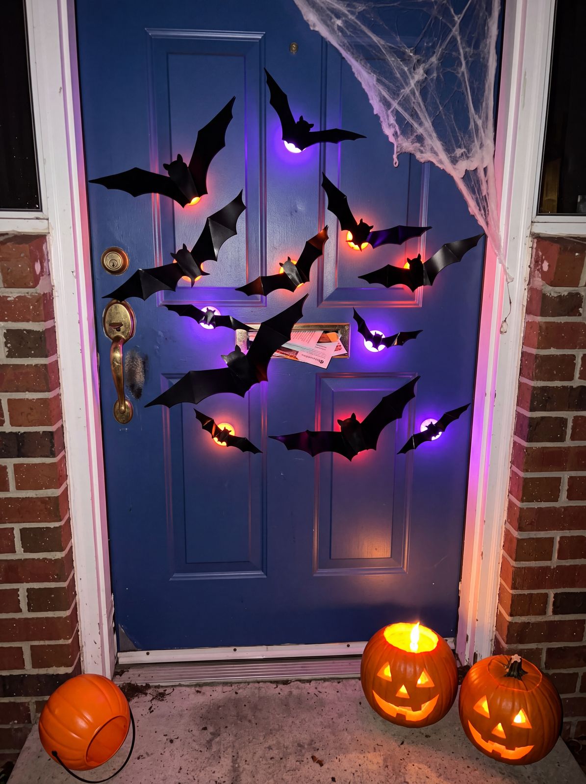 GlowBats porch display glowing at night with Halloween pumpkins
