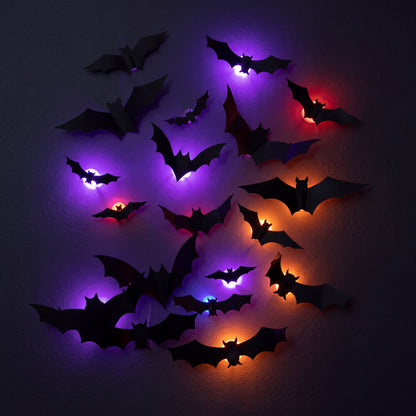 Tight cluster of nine GlowBats on a dark wall at night with overlapping violet, ember orange and deep red halos