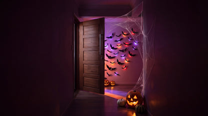 Half open door with a jack-o-lantern in the hallway and GlowBats glowing in the room beyond